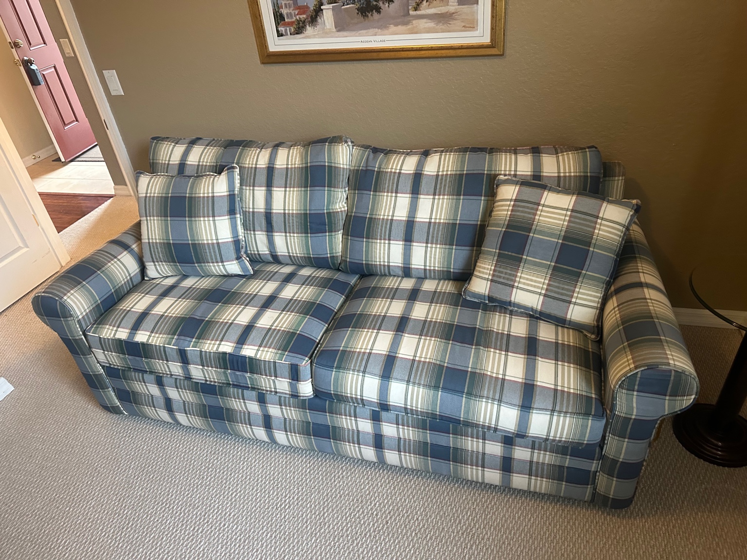 Plaid upholstered three-seat sofa with matching accent pillows in a Nashville home cleared before closing