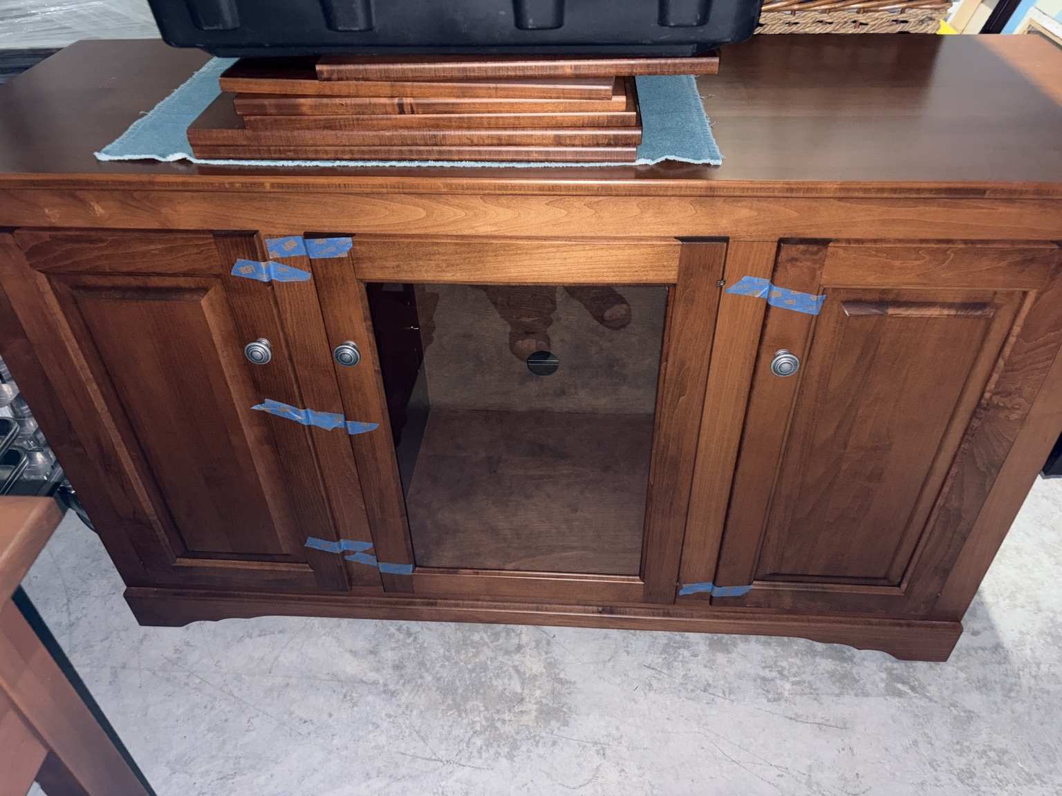 Cherry-finish media console with glass center door and adjustable shelves stored in a Nashville storage unit