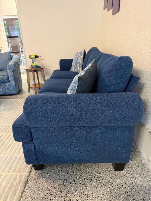 Side view of a navy blue rolled-arm sofa