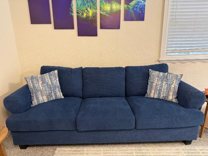 Navy blue three-cushion sofa with accent pillows