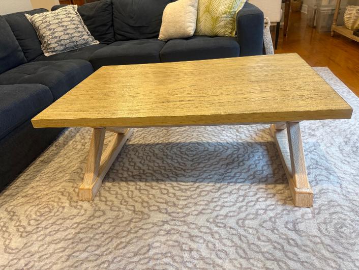 Rectangular light oak trestle coffee table in a living room