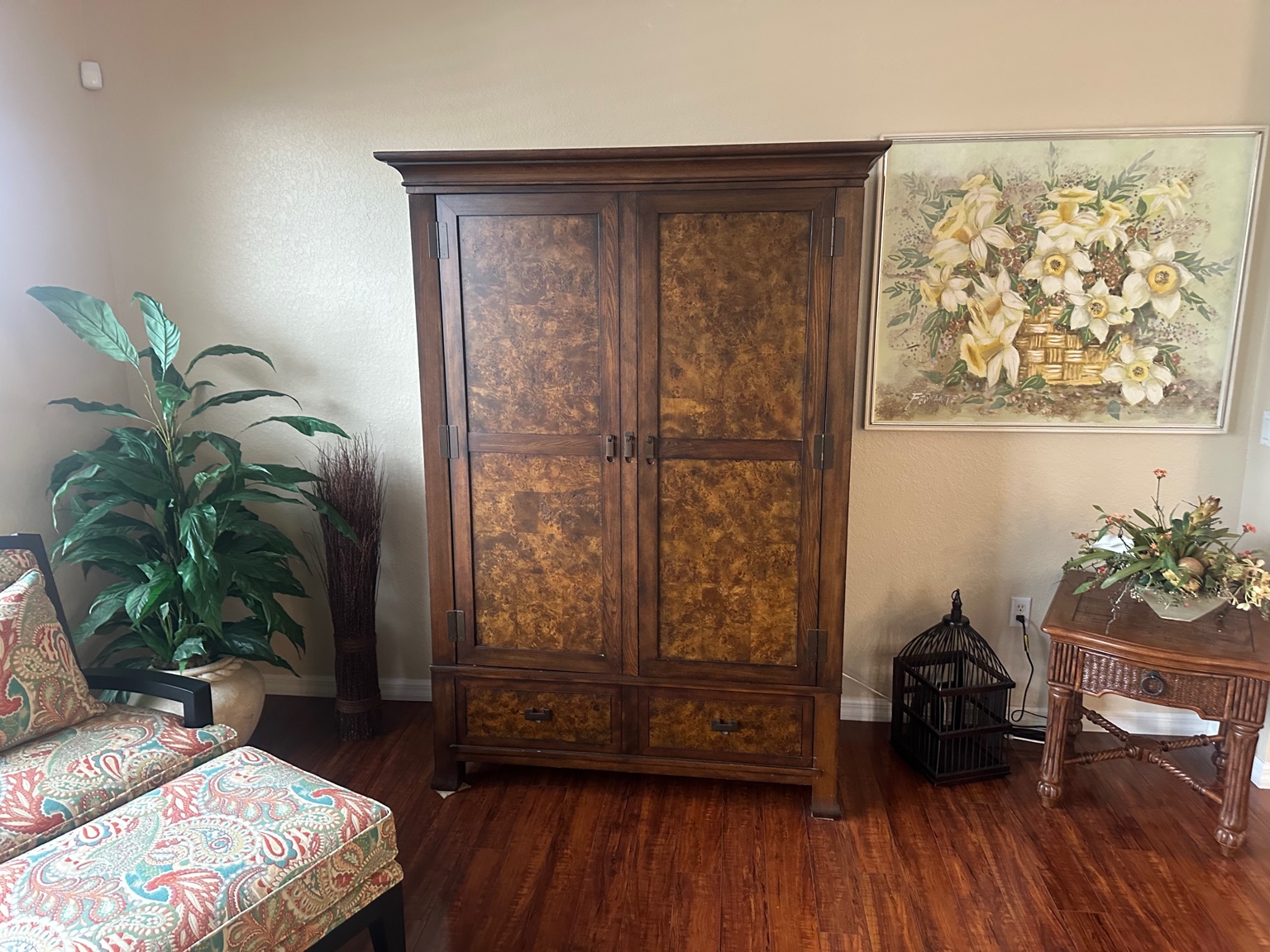 Large burl-panel wood armoire with lower drawers in the living room of a Nashville second home being sold