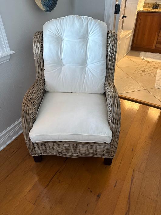 Woven rattan wingback armchair with white cushions